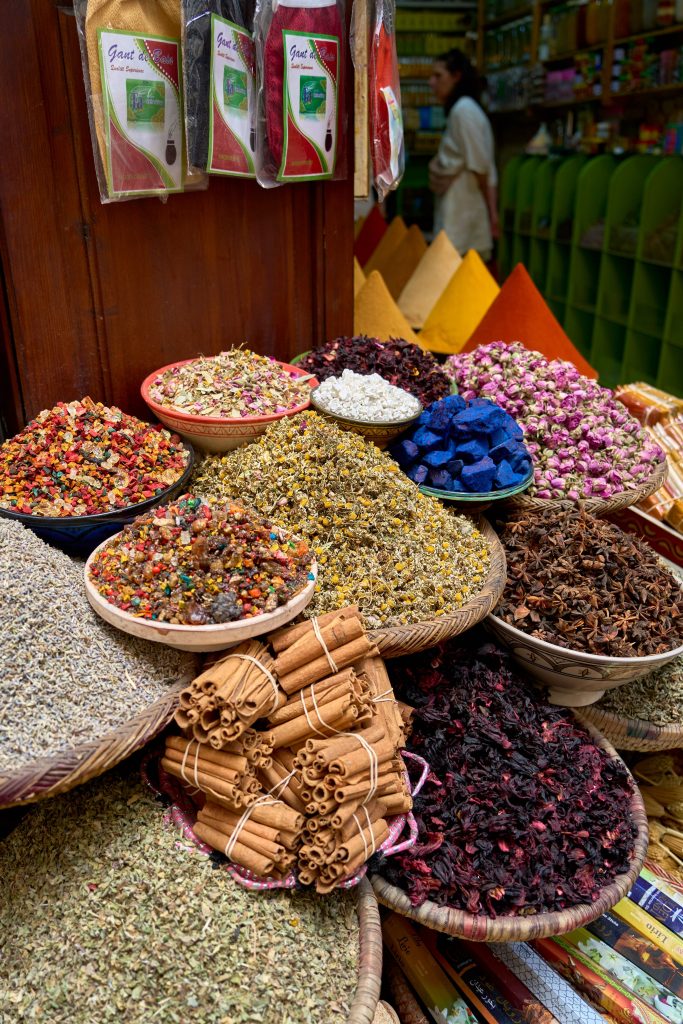 Colorful display of spices and herbs at a market stall in Marrakesh, showcasing traditional Moroccan flavors.